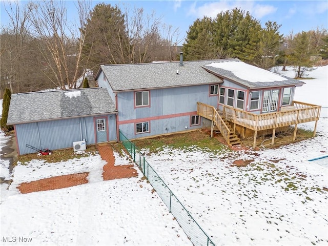 snow covered rear of property featuring a deck