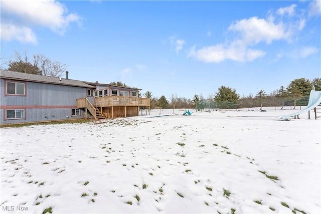 yard covered in snow with a deck