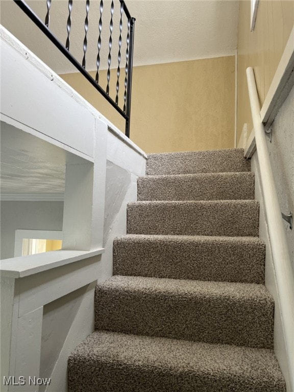 staircase featuring crown molding