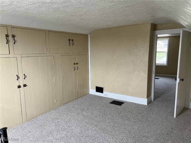 unfurnished bedroom with light colored carpet and a textured ceiling