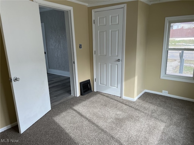 unfurnished bedroom with dark colored carpet