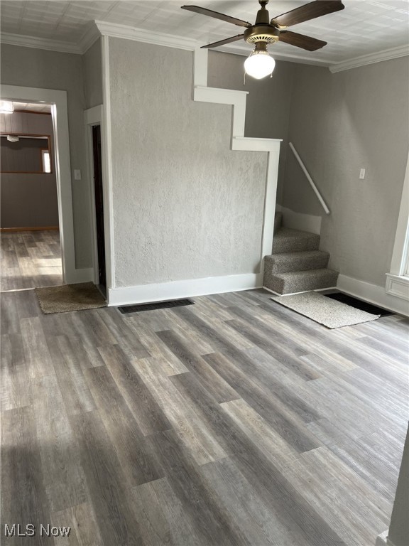 spare room featuring hardwood / wood-style flooring, crown molding, and ceiling fan