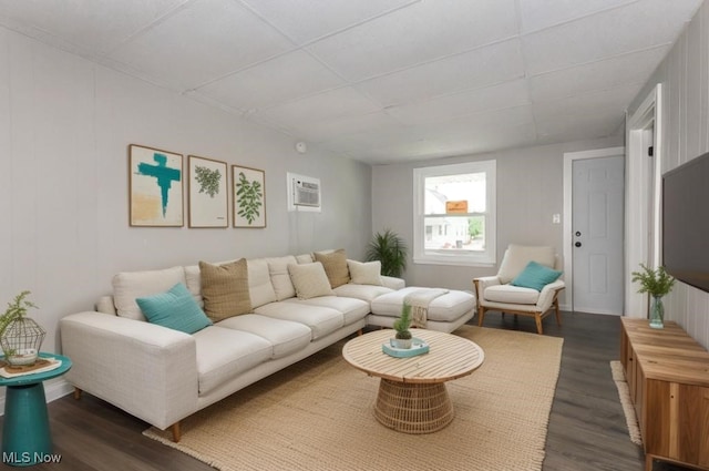 living room with dark hardwood / wood-style flooring and a wall unit AC