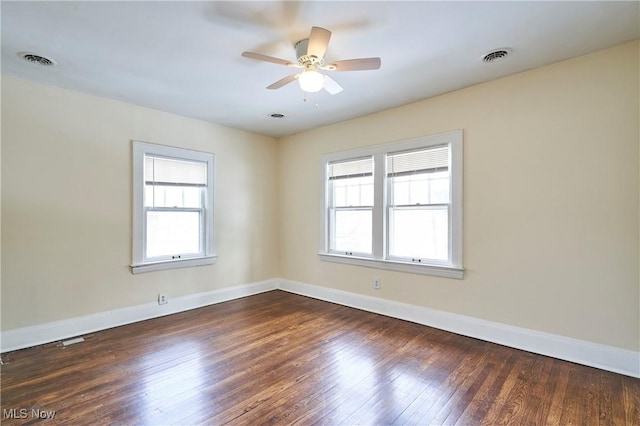 spare room featuring dark hardwood / wood-style flooring, a wealth of natural light, and ceiling fan