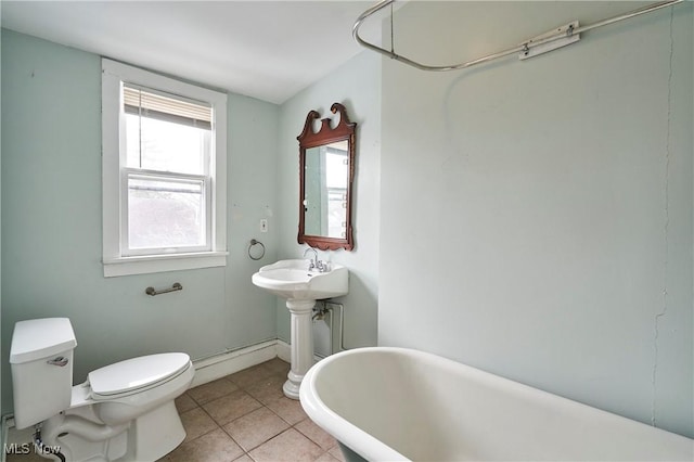 bathroom with a baseboard radiator, tile patterned floors, toilet, and a tub