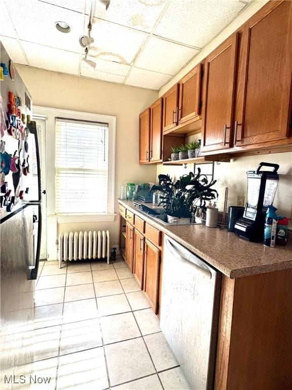 kitchen with dishwasher, radiator heating unit, a drop ceiling, and light tile patterned floors