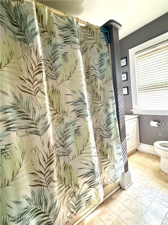 bathroom featuring toilet and tile patterned flooring