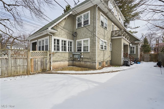 view of snow covered back of property