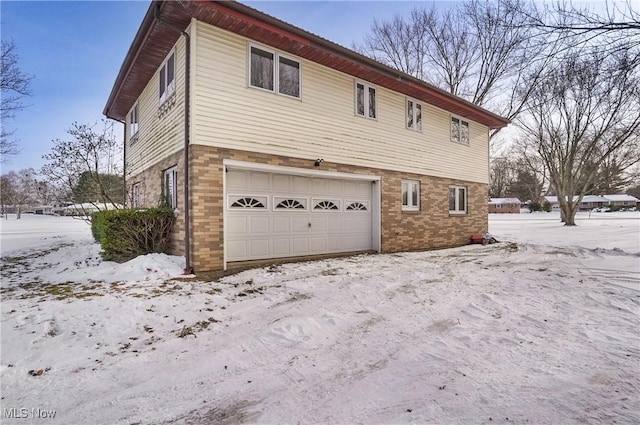 snow covered property with a garage