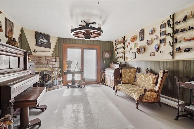 sitting room with a stone fireplace, carpet floors, and wood walls