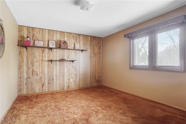 carpeted empty room with wood walls