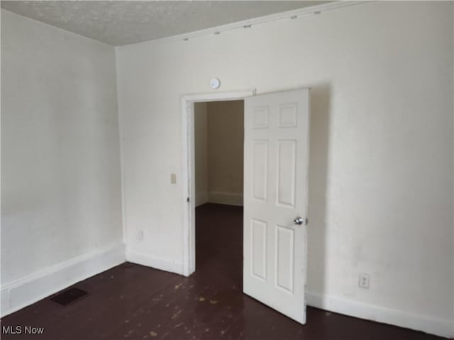 unfurnished room with a textured ceiling