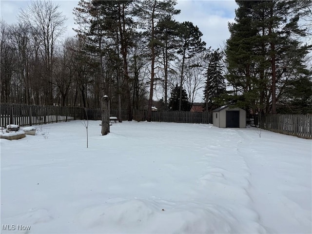 yard covered in snow featuring a storage shed