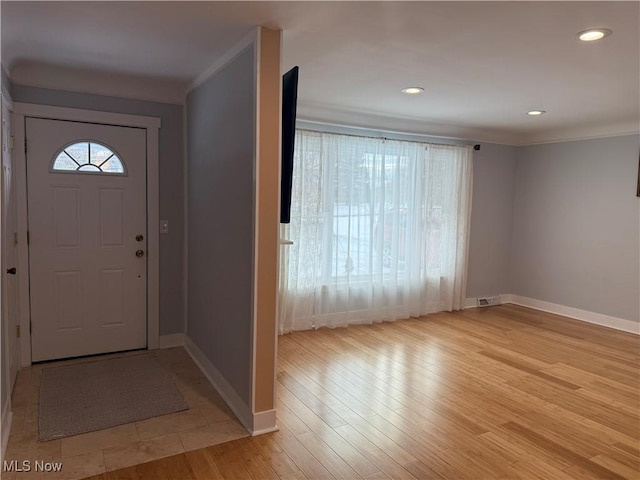 entrance foyer featuring ornamental molding and light wood-type flooring