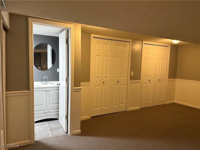 interior space featuring dark carpet and sink