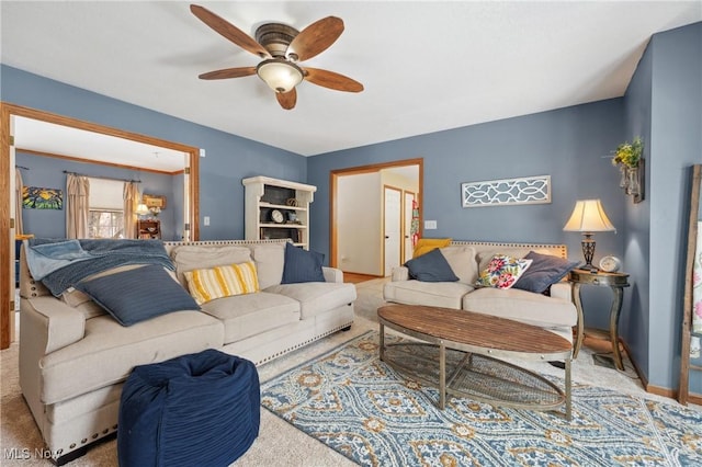 carpeted living room with ceiling fan