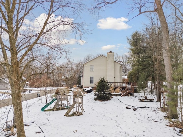 exterior space featuring a playground and a wooden deck