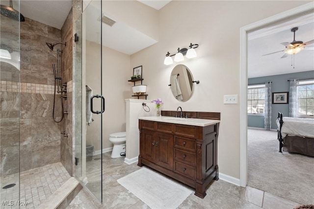 bathroom with vanity, toilet, ceiling fan, and a shower with shower door