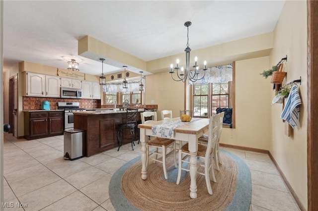 dining room with a notable chandelier, light tile patterned floors, and a wealth of natural light