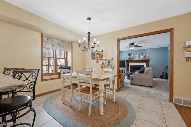 dining room featuring ceiling fan with notable chandelier and light tile patterned floors