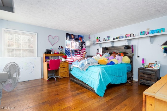 bedroom with dark hardwood / wood-style floors and a textured ceiling