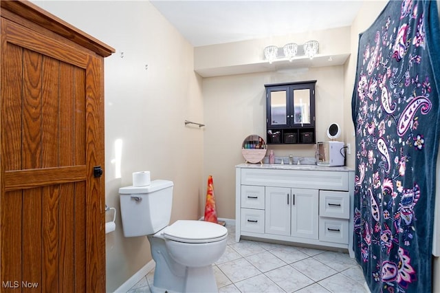 bathroom featuring vanity, tile patterned floors, and toilet