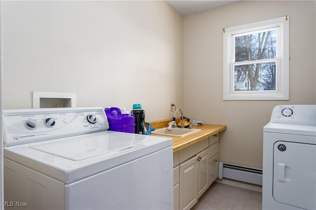 washroom featuring sink, light tile patterned floors, a baseboard heating unit, cabinets, and independent washer and dryer