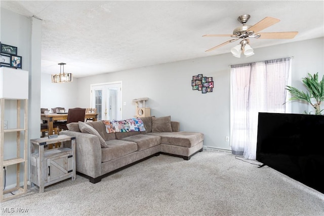 carpeted living room with ceiling fan, french doors, and a textured ceiling