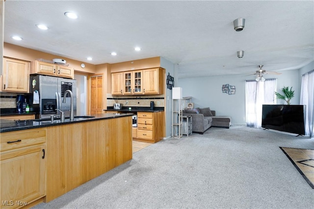 kitchen featuring light colored carpet, decorative backsplash, light brown cabinetry, and stainless steel fridge with ice dispenser