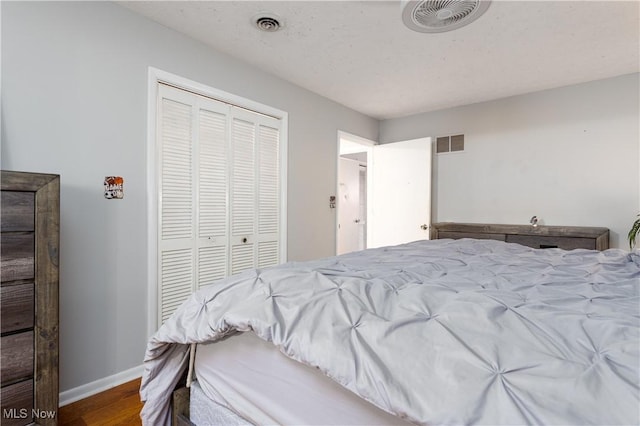 bedroom featuring wood-type flooring, a closet, and a textured ceiling