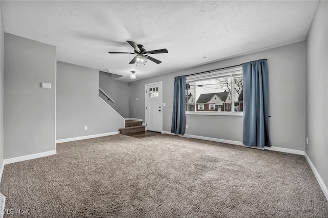 carpeted empty room featuring a textured ceiling and ceiling fan