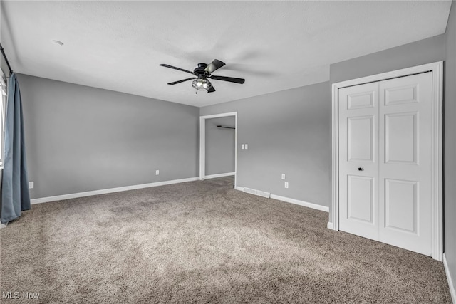 unfurnished bedroom with a textured ceiling, a closet, ceiling fan, and carpet