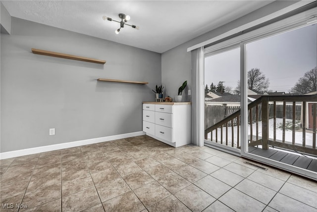 unfurnished bedroom with multiple windows and light tile patterned floors