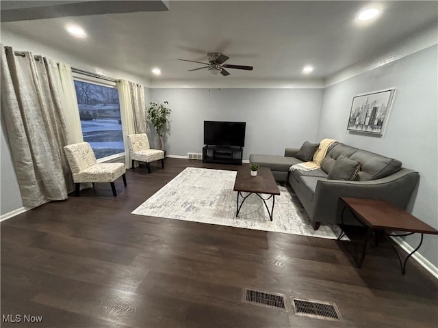 living room featuring dark wood-type flooring and ceiling fan