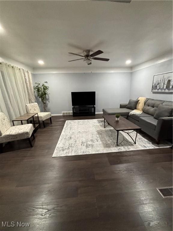 living room with ceiling fan and dark wood-type flooring