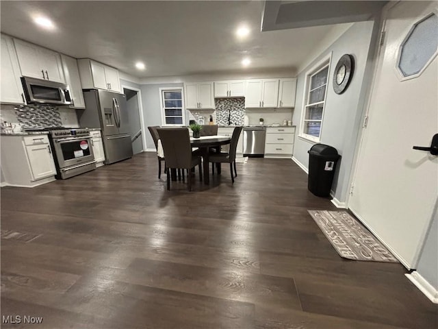 dining space featuring white cabinetry and dark hardwood / wood-style flooring