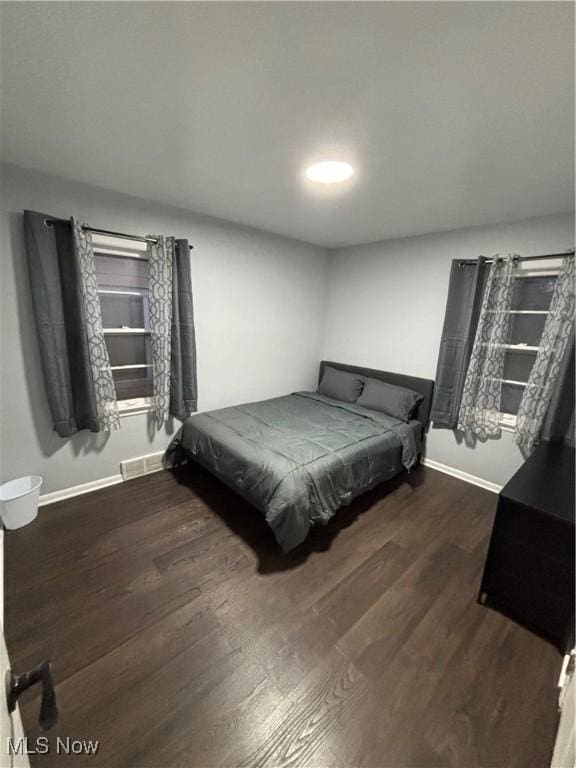 bedroom with dark hardwood / wood-style floors