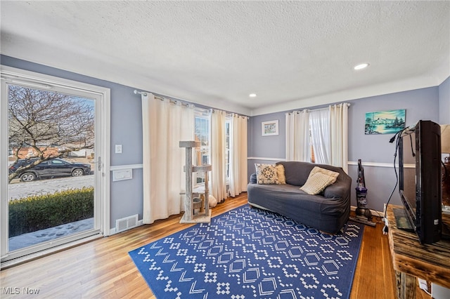 living room with hardwood / wood-style flooring and a textured ceiling