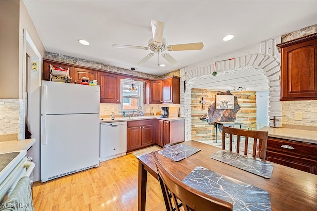 kitchen featuring sink, decorative backsplash, ceiling fan, white appliances, and light hardwood / wood-style flooring