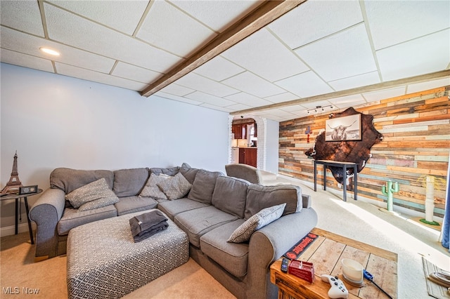 carpeted living room featuring wooden walls