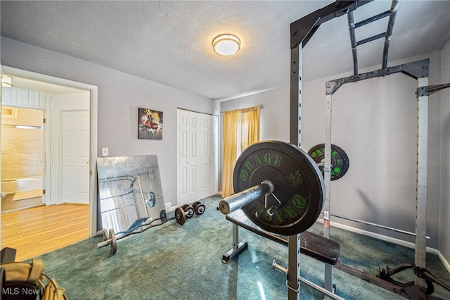 workout area featuring carpet flooring and a textured ceiling