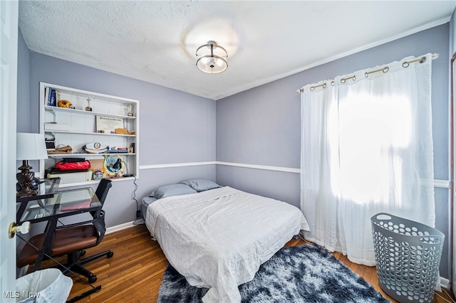 bedroom with dark wood-type flooring and a textured ceiling