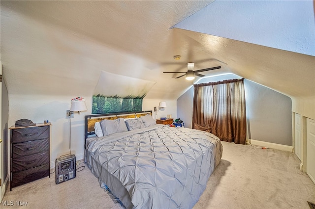 carpeted bedroom with ceiling fan, lofted ceiling, and a textured ceiling