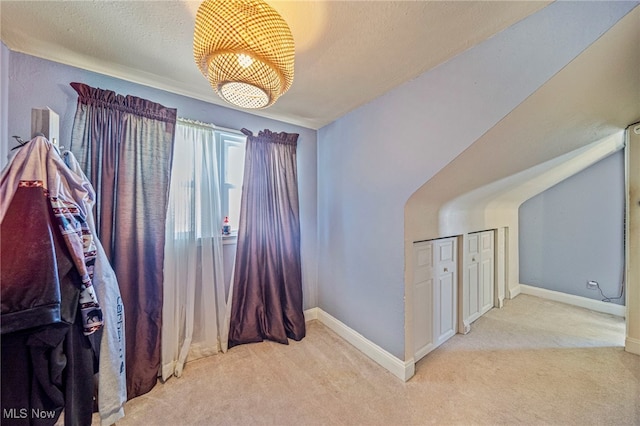 interior space with light colored carpet and a textured ceiling