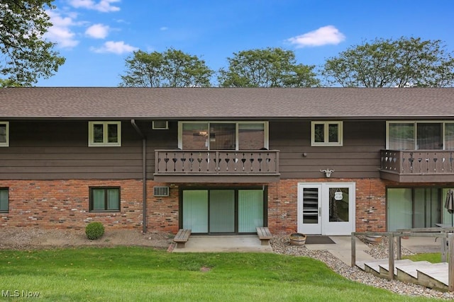 rear view of property with a patio, a balcony, and a yard