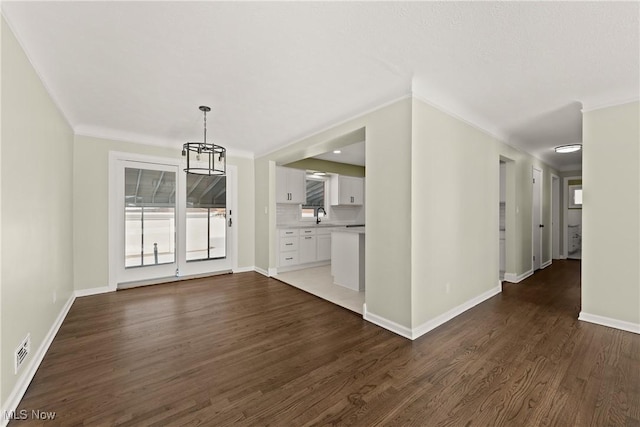 unfurnished dining area with crown molding, dark hardwood / wood-style floors, and sink