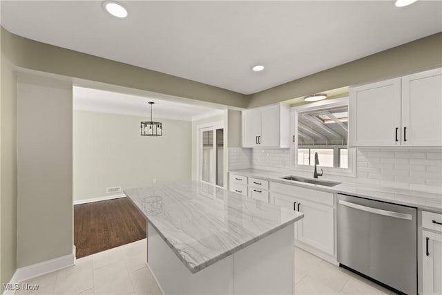 kitchen featuring white cabinetry, dishwasher, sink, a center island, and light stone countertops