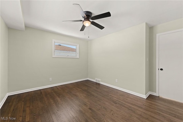 spare room featuring dark wood-type flooring and ceiling fan