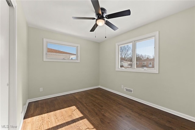 empty room featuring hardwood / wood-style floors, a wealth of natural light, and ceiling fan