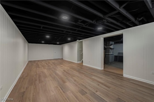 basement with heating unit and wood-type flooring